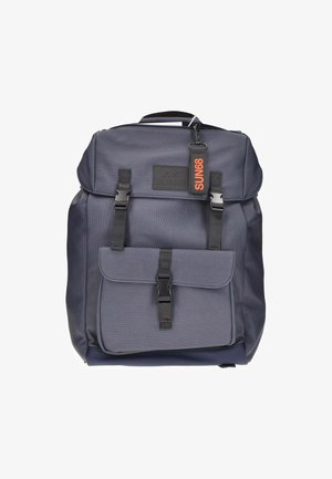Mochila gris oscuro hecha de tejido duradero. Presenta correas ajustables, un bolsillo frontal con un broche y una etiqueta con el logo en naranja.
