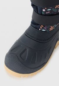 Gyerek vízálló téli csizma fekete gumitorrá, virágmintás textil felsőrész, és bézs bordázott talp.