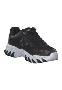 Sneaker nera con tomaia in rete e pelle, caratterizzata da un lato marrone a motivi e una suola chunky bianca con accenti neri e un design testurizzato.