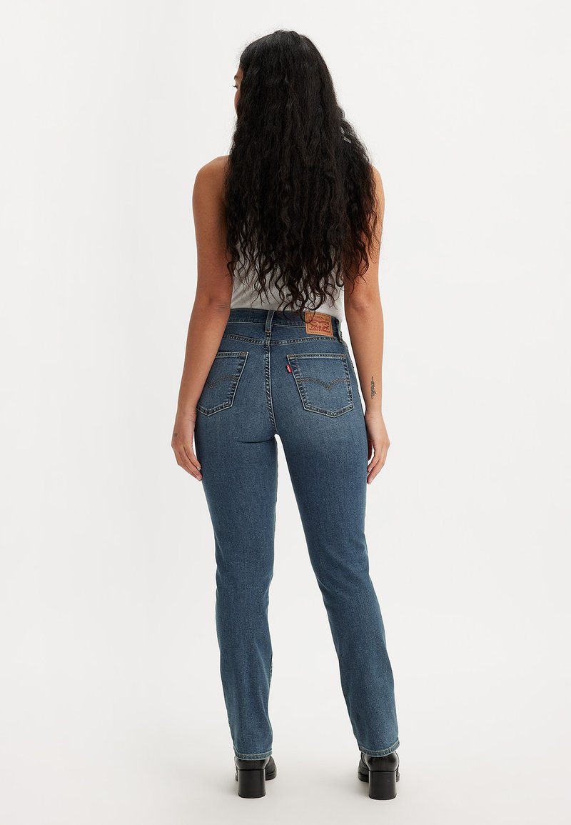 Hochtaillierte blaue Jeans aus Denim mit geradem Schnitt, ausgestattet mit Gesäßtaschen und einem Leder-Logo-Patch an der Taille. Strukturierter Stoff.