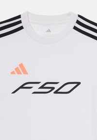 Maglietta sportiva bianca con accenti neri e arancioni, presenta tre strisce nere sulle spalle e un grande "F50" in grassetto nero.
