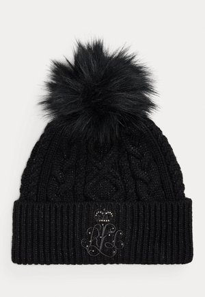 Svart stickad mössa med en stor fluffig pom-pom på toppen och en dekorativt broderad logotyp med en krona på mudd.