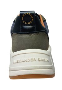 Sneaker con una toma superiore testurizzata grigia e nera, dettagli arancioni e suola bianca. Presenta un tassello del tallone nero con "ALEXANDER SMITH" in oro.