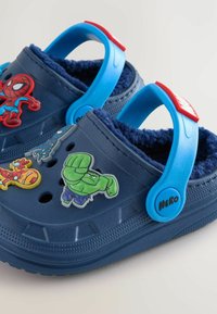Crocs bleu marine avec des bretelles bleues douces, ornés de personnages Marvel : Spiderman, Hulk et Iron Man. Intérieur en textile.