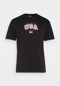 Black cotton t-shirt featuring a bold white and red graphic print reading "TOMMY USA JEANS" and a small logo at the bottom. Round neckline.