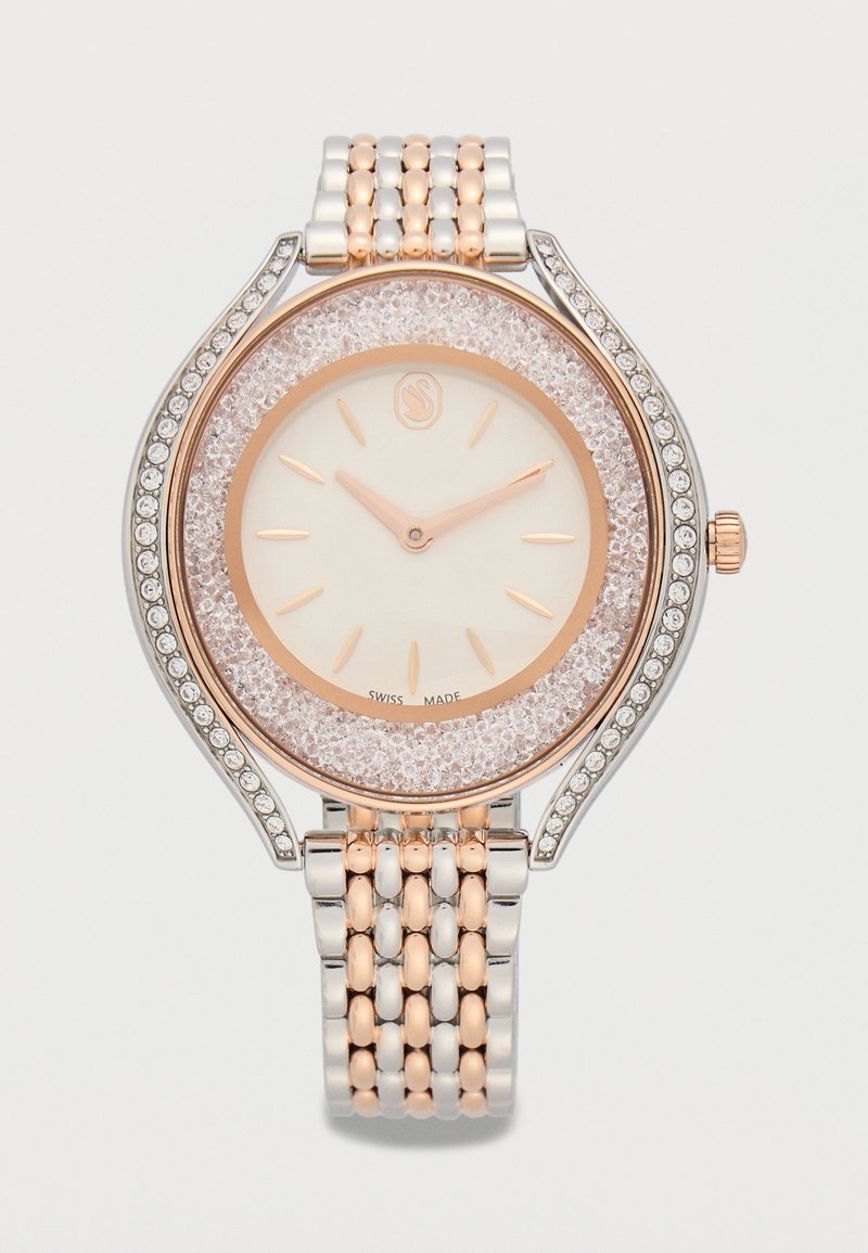 Luxe polshorloge met een metalen band in twee tinten, roségouden accenten, met kristallen ingelegde lunette en een minimalistische wijzerplaat die 10:12 aangeeft.