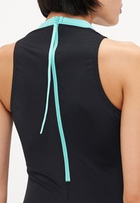 Svart ärmlös bodysuit med en turkos dragkedja på baksidan, som framhäver en åtsittande design och en mjuk textur.