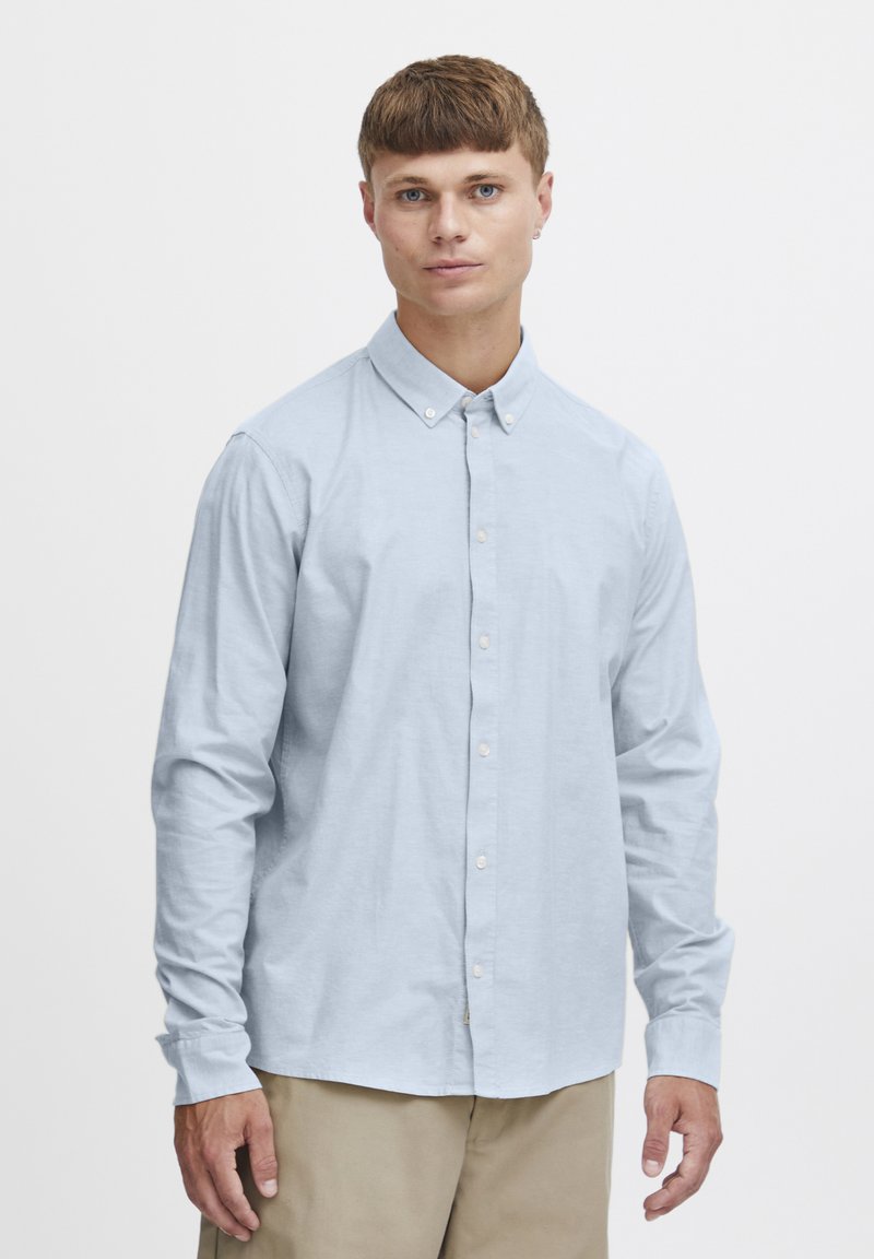 Lichtblauwe longsleeve shirt met button-down kraag, zachte katoenstof en normale pasvorm, gecombineerd met beige broeken.