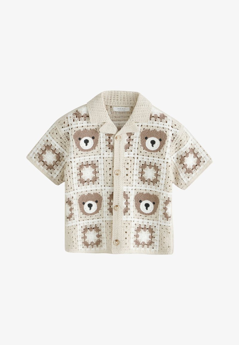 Camisa de crochet beige de manga corta con botones delanteros, con un patrón de caras de ositos de peluche y cuadrados en forma de estrella.