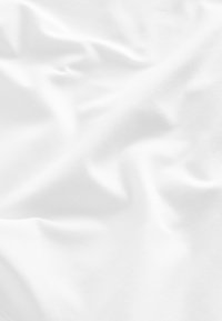 Fehér szövet sima textúrával, lágy redőkkel és finom hullámokkal, amelyek könnyű és rugalmas anyagot jeleznek.