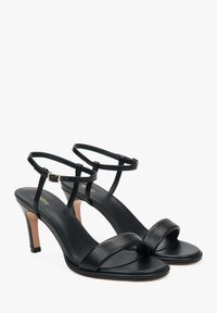 Zwarte leren sandalen met hoge hakken, dunne enkelbandjes, vierkante gesp en een gladde textuur. Beschikt over een slanke hak en een minimalistisch ontwerp.