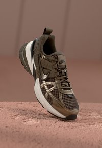 Nike Sneaker in olivgrün mit Obermaterial aus Mesh, kontrastierenden schwarzen Akzenten, strukturierten Sohle und Schnürdesign.