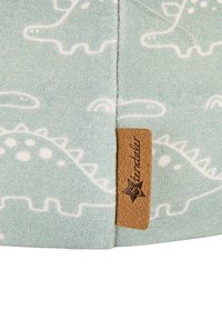 Light blue fabric featuring white dinosaur patterns and a textured tan leather tag embossed with "Stentale." Soft and smooth texture.