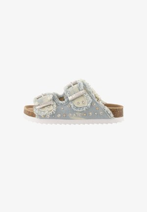 Sandalo tipo slide in denim azzurro chiaro con bordi sfrangiati, due fibbie regolabili, decorazioni con borchie, suola in sughero e suola esterna bianca rigata.