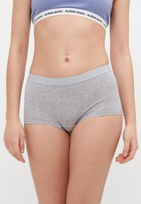 Szürke pamut boxeralsó, puha textúrával, világosszürke logós derékrésszel. A fazon illeszkedő stílus, minimális varrásokkal.