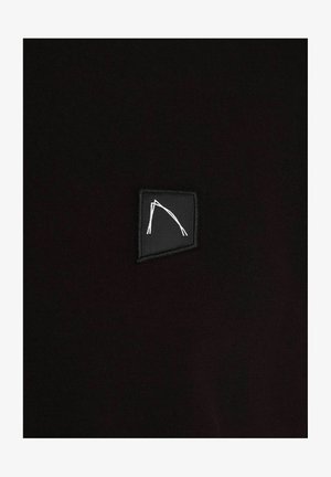 Țesătură neagră cu o textură moale, având o mică pată neagră cu un logo geometric alb. Designul este minimalist și modern.