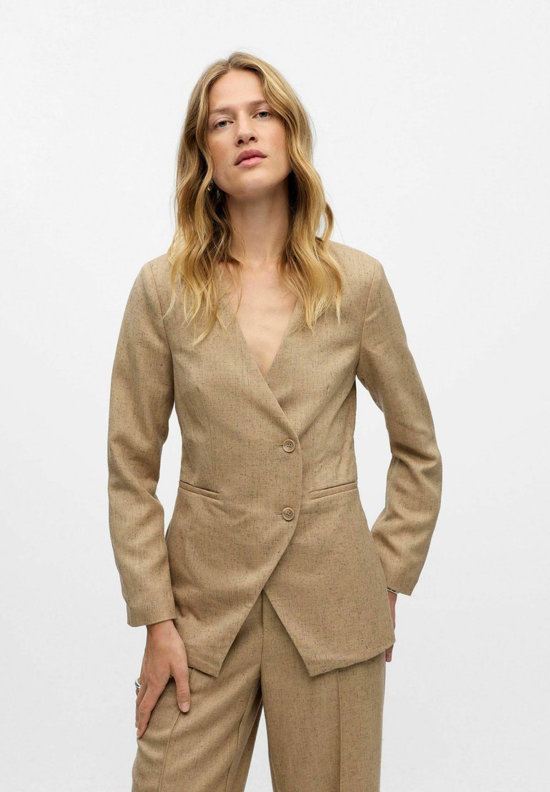 Beiger taillierter Blazer mit V-Ausschnitt, einreihigem Design, zwei Knöpfen und vorderen Taschen. Aus strukturiertem Stoff gefertigt.