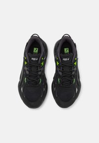 Mustat ja vihreät urheilukengät, joissa on verkko- ja synteettinen päällinen, pyöreä kärki, nauhakiinnitys ja teksturoitu kumipohja.