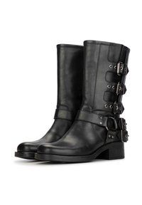 Botas de tobillo de piel negra con acentos de hebilla en el lado exterior y diseño de punta cuadrada. Textura suave y tacones bajos apilados.