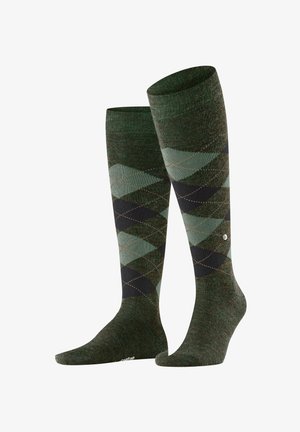 Kniestrümpfe in einem grünen und schwarzen Argyle-Muster. Hergestellt aus strukturiertem Material mit kontrastierenden rautenförmigen Mustern und dezenten Nahtakzenten.