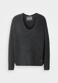 Pull en laine gris foncé à manches longues et col en V, avec une petite étiquette ronde en métal près de l'ourlet inférieur sur fond blanc.