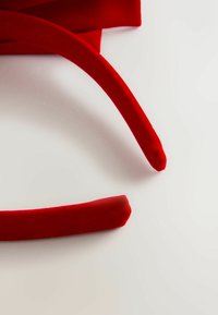 Rote Stoffhaarschmuck mit weicher, glatter Textur. Ein Stück hat ein abgerundetes Ende, während das andere eine spitz zulaufende Spitze hat.