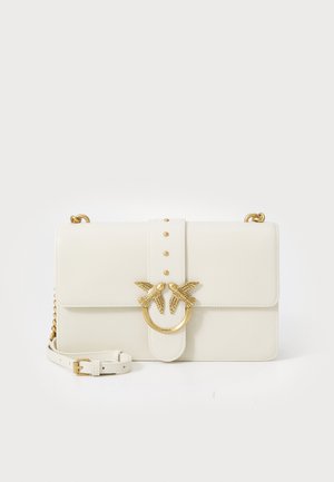 Biała skórzana torebka z okrągłą metalową klamrą w kolorze złotym, ozdobioną dwoma ptakami. W komplecie jest odpinany pasek oraz zapięcie na klapkę z akcentami w postaci ćwieków.