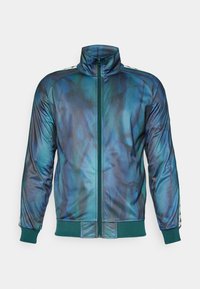 Chaqueta de cremallera en un degradado de azul profundo y verde azulado, confeccionada en una tela suave. Presenta un cuello alto y puños y dobladillo de canalé en un contraste verde.