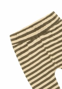 A bordázott leggings vízszintes csíkokkal rendelkezik olajzöld és krémszínben, rugalmas derékrésszel és testhezálló fazonban.
