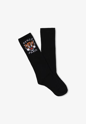 Chaussettes noires montantes jusqu'aux genoux avec un motif tigre brodé et le texte "KENZO PARIS" sur le bord-côte, fabriquées dans un tissu lisse et extensible.
