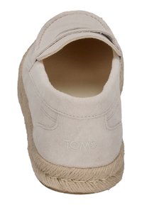 Beige suède instappers met een ronde neus, geborduurde textuur en een natuurlijke touwzool. "TOMS" logo is in de hiel gedrukt.