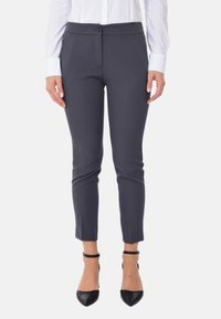 Pantaloni sartoriali grigio scuro con fronte piatto, vestibilità slim e orlo alla caviglia. Presentano una chiusura con bottone e dettagli di piega sottili.