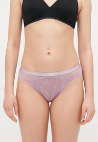 Lavendel Spitzenunterhosen mit einem Satinbund. Blumendesign auf der Spitze, gewellter Saum und halbtransparenter Stoff.