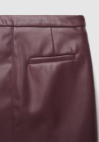Jupe en cuir bordeaux avec une texture lisse, une silhouette élégante et une poche arrière discrète avec un détail de couture.