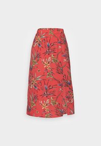 Jupe midi florale rouge avec une taille élastique, ornée de fleurs vertes et jaunes éclatantes, et en tissu léger et fluide.