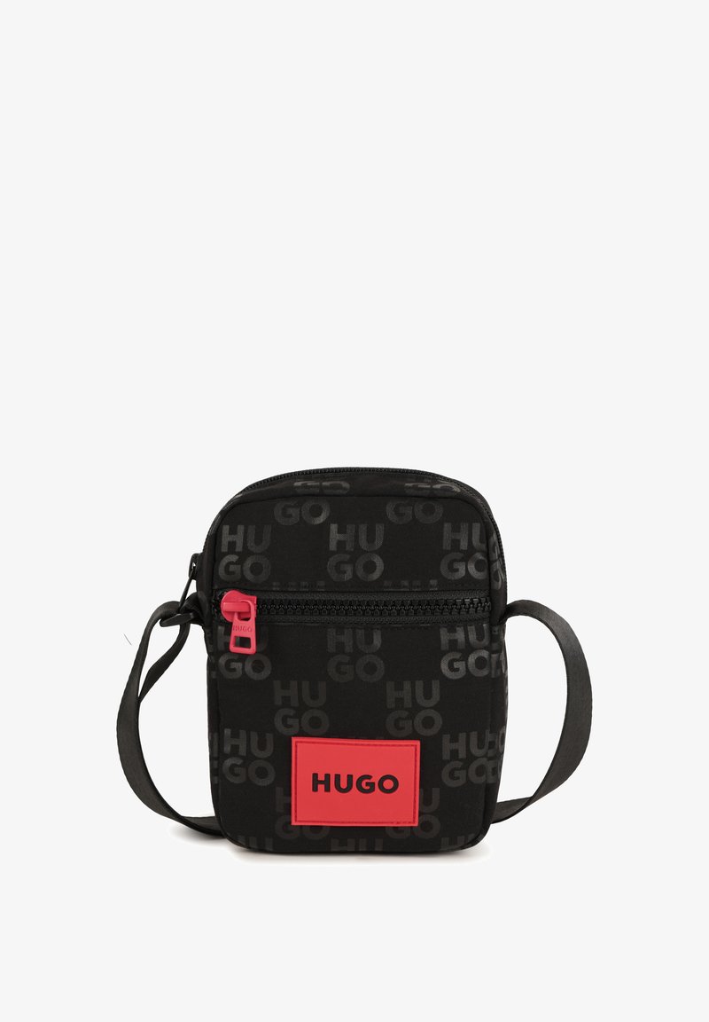 Melna auduma plecu soma ar atkārtotu "HUGO" logotipa rakstu. Iezīmēta ar sarkanu rāvējslēdzēja pievilkšanas detaļu un rozā logotipa uzlīmi taisnstūra formā.