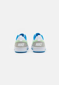 Nike sneakers with a white upper, gray heel, light green accents, and blue detailing. Features a blue sole and prominent logo on the back.