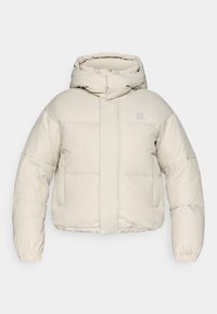 Gevoerde crèmekleurige jas met capuchon, voorzien van een ritssluiting aan de voorkant, elastische manchetten en een vierkant gestikt patroon. Minimalistisch ontwerp.