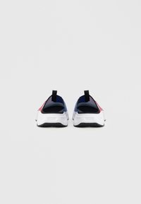 Buty sportowe wsuwane z teksturowaną siateczkową cholewką, z wzorem bloków kolorów w odcieniach czerwieni, niebieskiego i czerni oraz białą gumową podeszwą z przyczepnością.