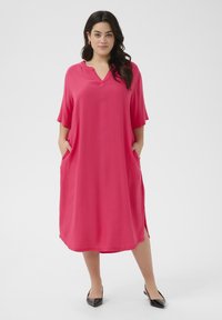Pink knee-length dress with a v-neck, short sleeves, and side pockets. Smooth fabric and relaxed fit provide comfort and ease of movement.