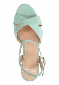 Muntgroene suède sandaal met kruislings gespen en een gesp sluiting. Kenmerkt zich door een gladde binnenzool en een ronde neus.