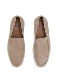 Zapatos de ante beige claro sin cordones con una textura suave, punta redondeada y suela de goma blanca. Presentan costuras delicadas a lo largo de los bordes.