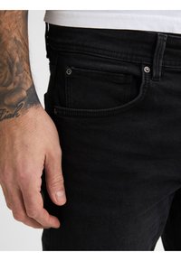 Zwarte denim jeans met een slim-fit ontwerp, vijf zakken en een knoopsluiting op de tailleband. Gladde textuur, zonder zichtbare patronen.