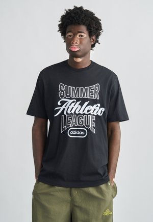 Fekete pamut póló fehér "SUMMER ATHLETIC LEAGUE" felirattal és Adidas logóval. Párosítva olívzöld rövidnadrággal, laza szabással.