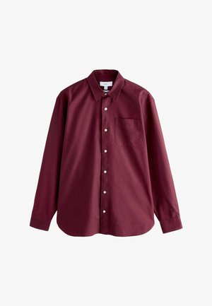 Burgundia pikkade varrukatega särk klassikalise krae, nuppe ees ja ühe rinna-taskuga. Valmistatud siledast puuvillakangast.