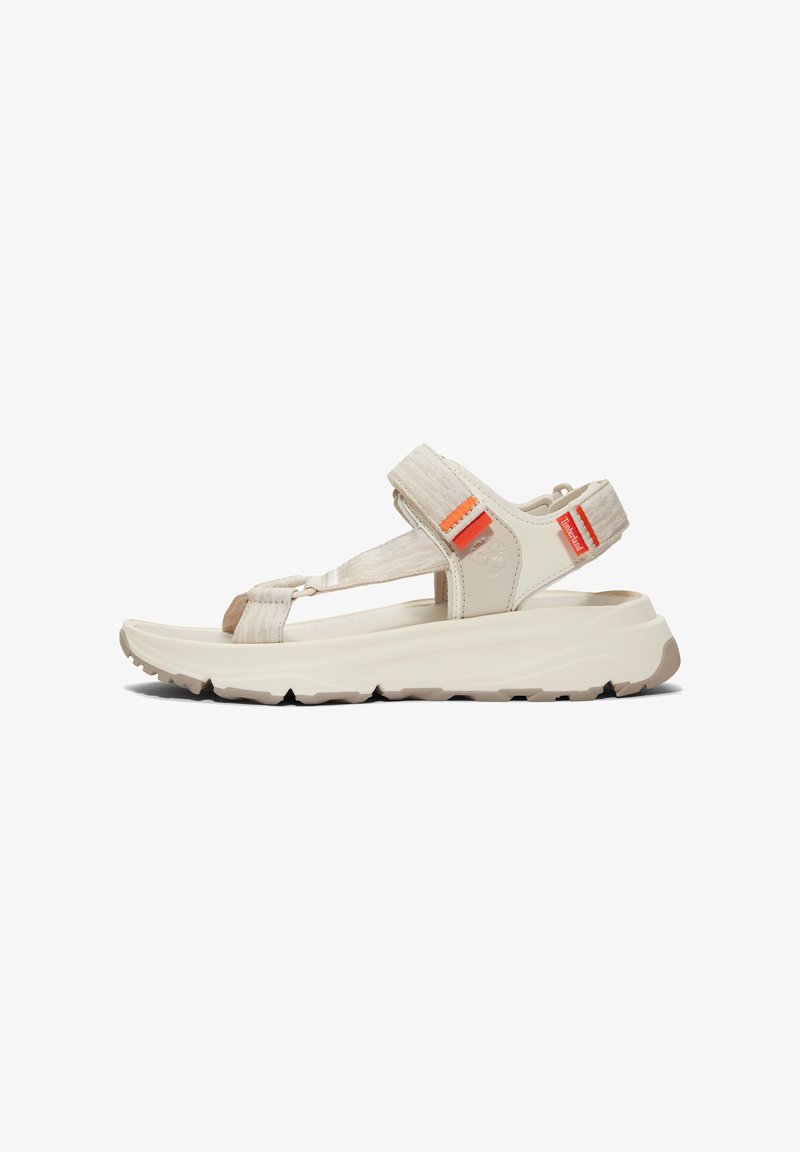 Beige synthetic sandals with wide straps, textured accents, and orange detailing. Features a cushioned sole with a rugged tread pattern for grip.