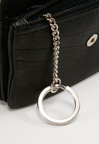 Portefeuille en simili cuir noir avec fermeture éclair, équipé d'une chaîne en métal argenté et d'un anneau pour porte-clés ou accessoire.