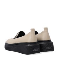 Béžové syntetické slip-on boty s kulatou špičkou, kontrastní černou gumovou podrážkou a texturovaným, vroubkovaným designem. Logo značky na patě.