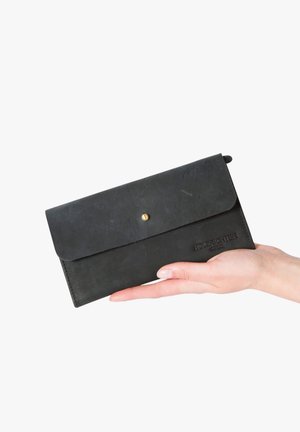 Black leather wallet with a flap closure, gold snap button, and embossed logo. Smooth texture, rectangular shape, and minimalist design.