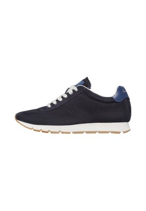 Navy blue suede sneaker with white laces, contrasting blue accents, perforated details, and a white midsole with a beige outsole.